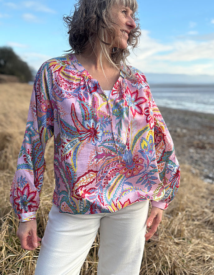 woman wearing a rose floral cotton blouse with white summer jeans