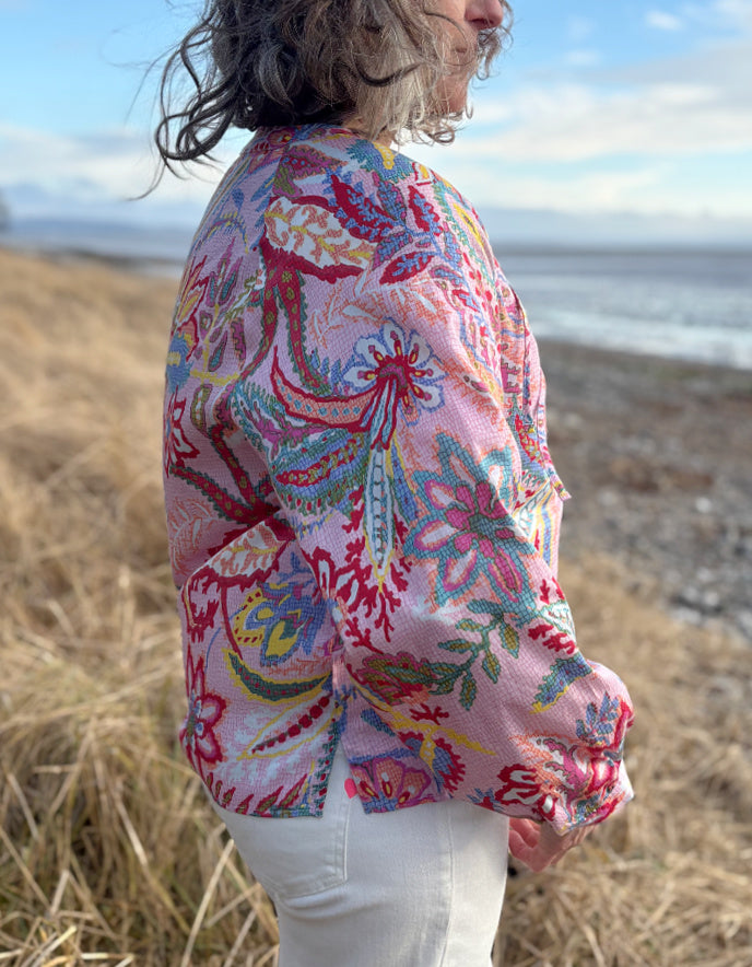 woman wearing a rose floral cotton blouse with white summer jeans