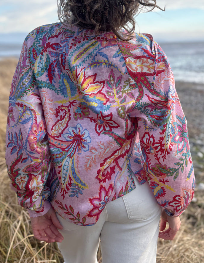 woman wearing a rose floral cotton blouse with white summer jeans