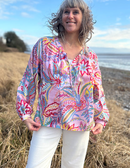 woman wearing a rose floral cotton blouse with white summer jeans