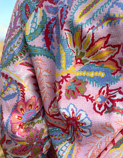 woman wearing a rose floral cotton blouse with white summer jeans