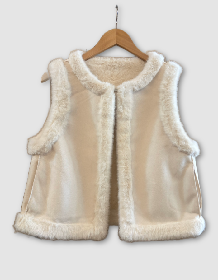 A cream-colored sleeveless vest with fluffy faux-fur trim, hanging on a wooden hanger against a light gray background.