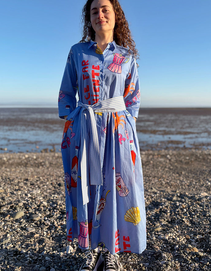 Woman wearing a colorful dress with text and graphics on a beach