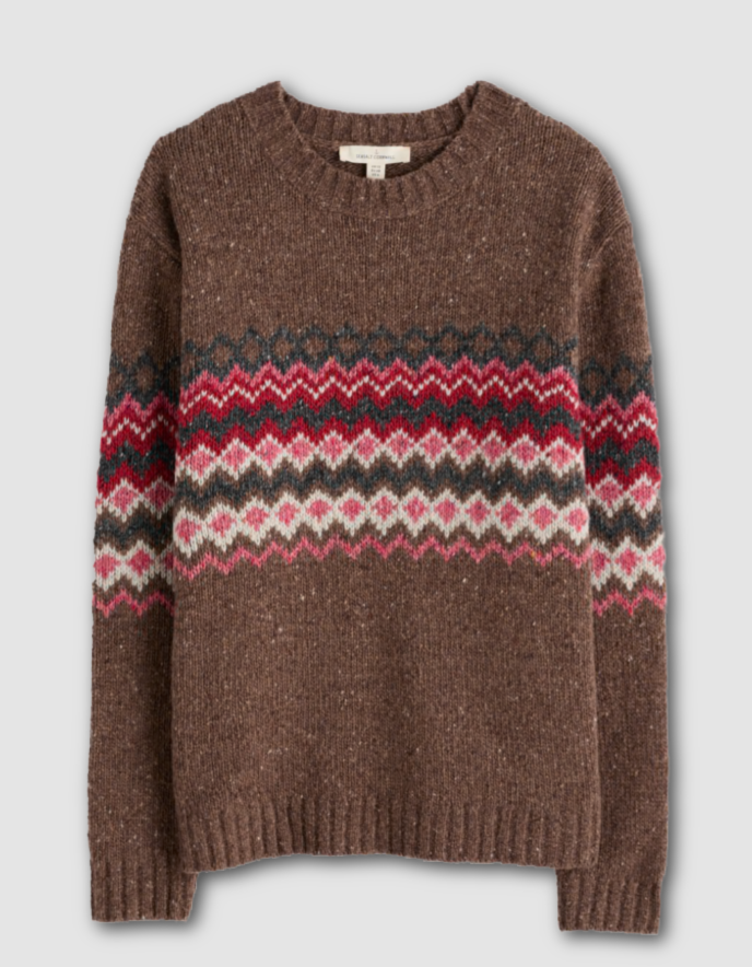 Person wearing brown and pink a fair isle patterned sweater with a neutral background