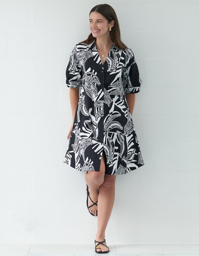Woman wearing a black and white patterned dress against a white background