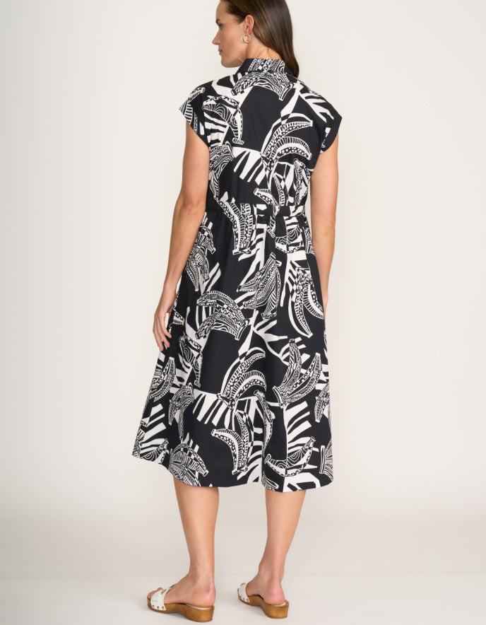 Woman wearing a black and white patterned dress on a white background