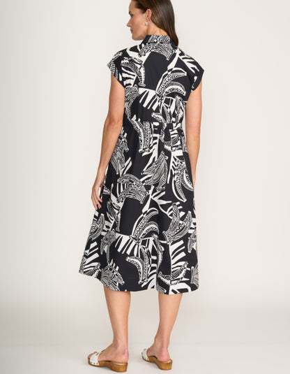 Woman wearing a black and white patterned dress on a white background