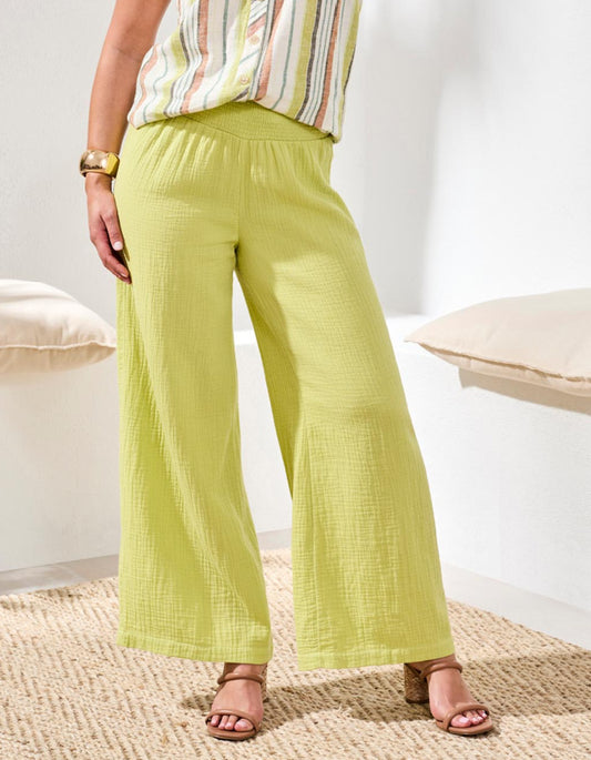 Person wearing light green wide-leg pants with a striped top in a neutral setting.