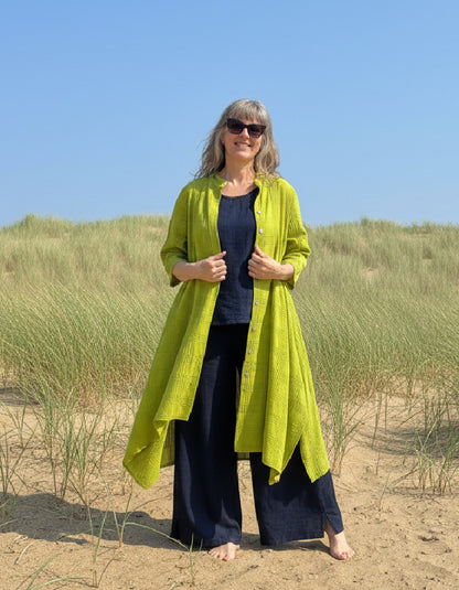 woman wearing lime cotton coat dress on a beach