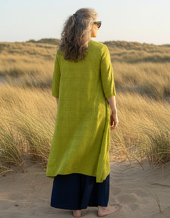 woman wearing lime cotton coat dress on a beach
