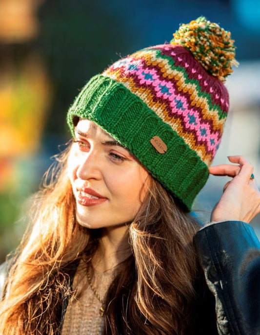 Woman wearing a colorful knitted beanie with a blurred outdoor background