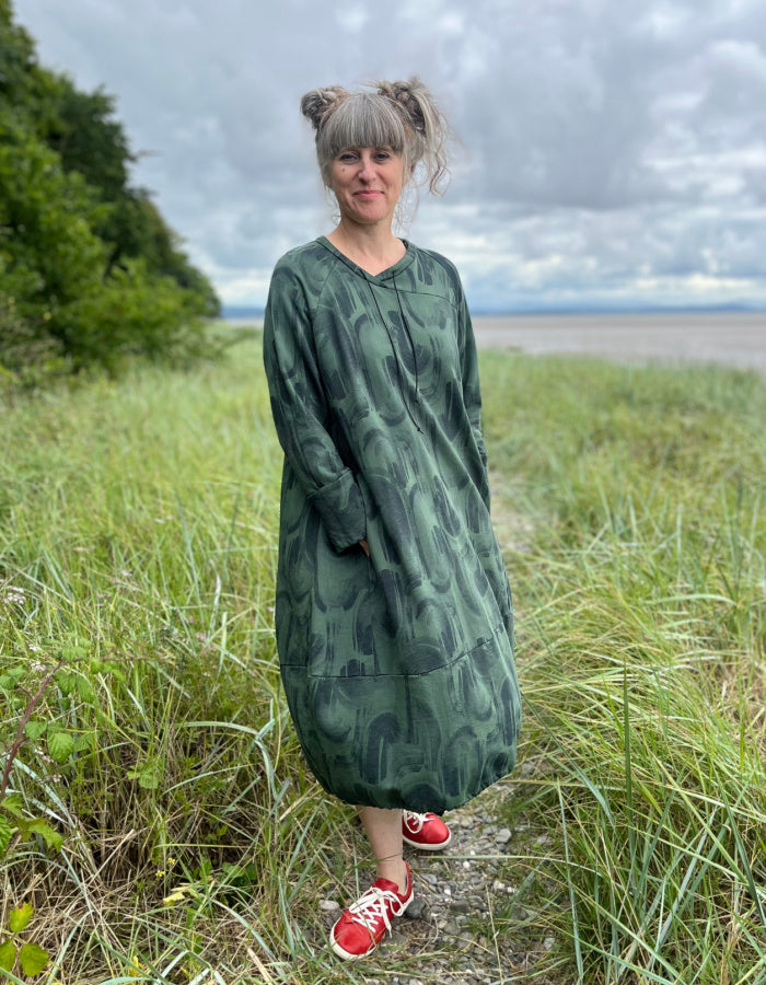 green jersey midi length bubble shaped dress with full length sleeves  and pockets, graphic swirl print on the fabric