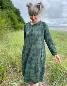 green jersey midi length bubble shaped dress with full length sleeves and pockets, graphic swirl print on the fabric