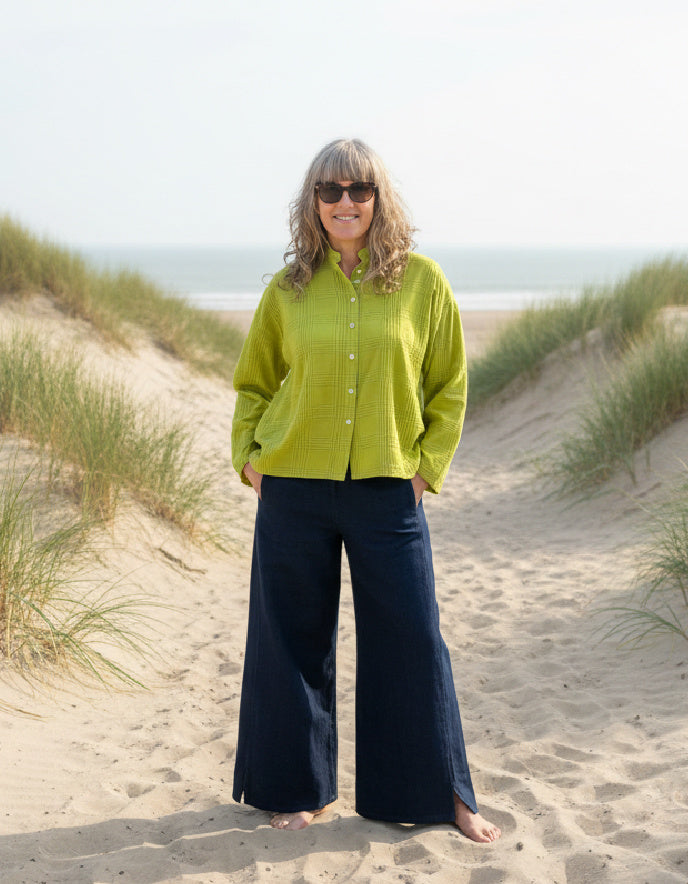 woman wearing lime cotton boxy shirt on a beach