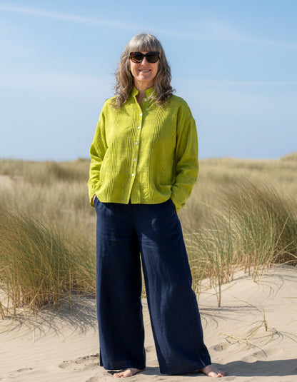 woman wearing lime cotton boxy shirt on a beach