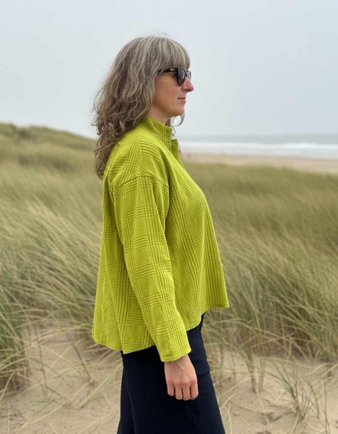 woman wearing lime cotton boxy shirt on a beach