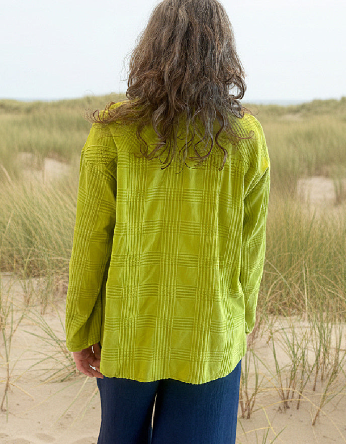 woman wearing lime cotton boxy shirt on a beach