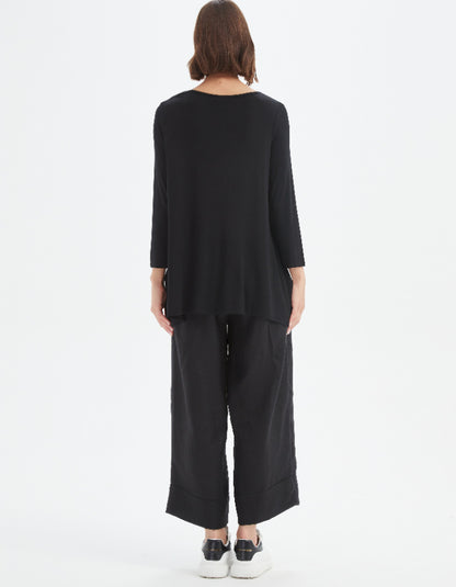 Person wearing a black outfit on a white background