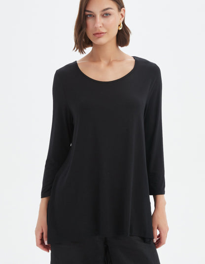 Woman wearing a black long-sleeve top on a white background