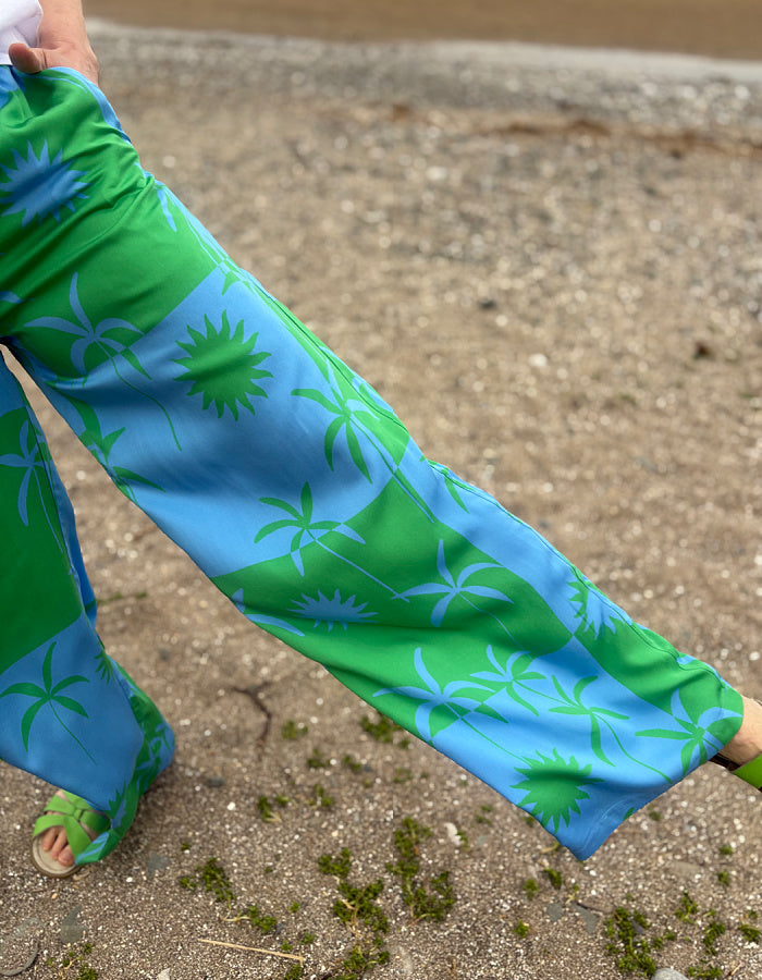 silky palazzo trousers with elasticated waist and wide leg in green and blue palm tree print