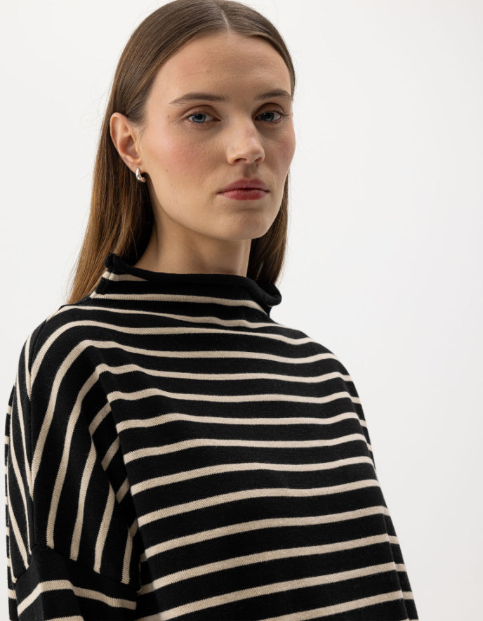 Woman wearing a navy and cream striped cottonsweater on a white background