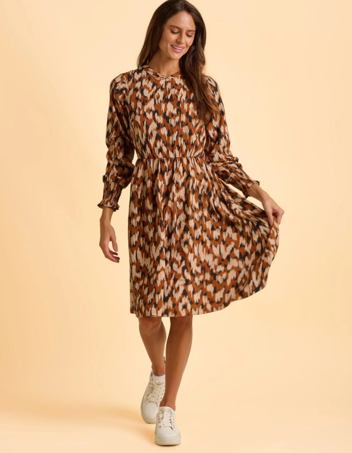 Woman wearing a patterned dress on a beige background