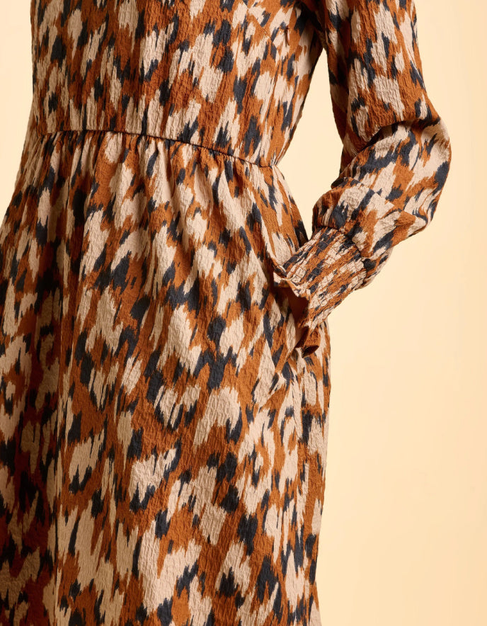 Patterned dress with long sleeves on a beige background