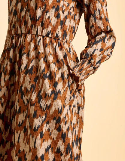 Patterned dress with long sleeves on a beige background