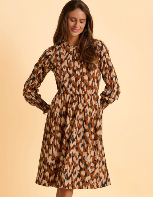 Woman wearing a animal print patterned dress on a beige background