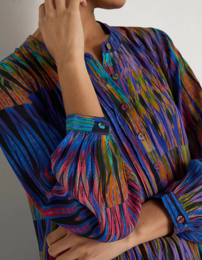 Multicolored patterned shirt worn by a person, with a neutral background
