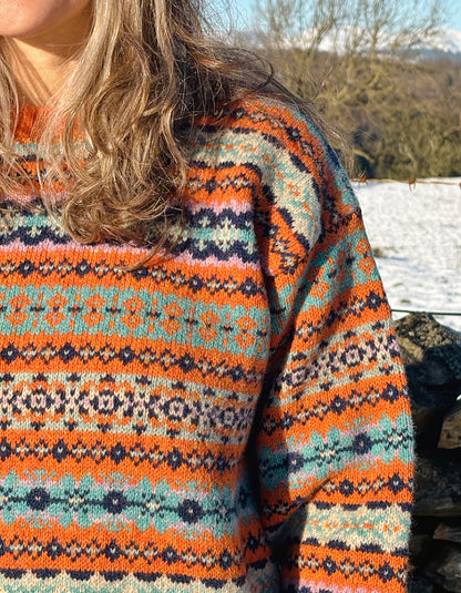 orange and teal all over Fair Isle sweater with orange ribbed hem cuffs and neckline. made from lambswool supersoft