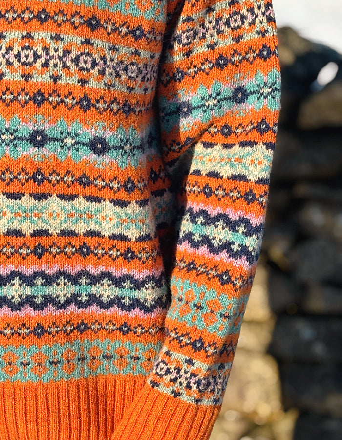 orange and teal all over Fair Isle sweater with orange ribbed hem cuffs and neckline. made from lambswool supersoft