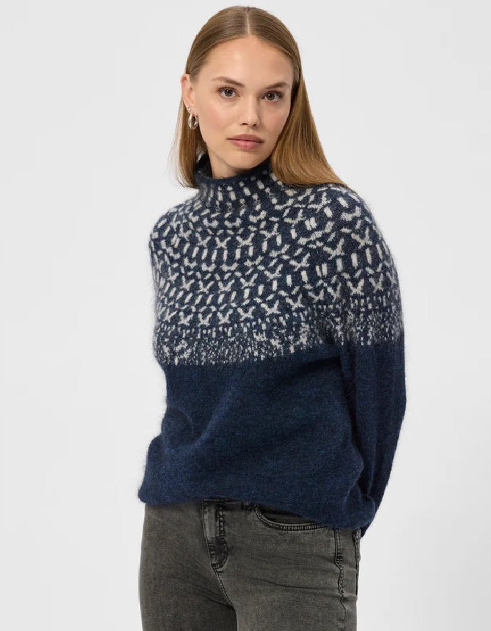 Woman wearing an Icelandic patterned navy sweater on a white background