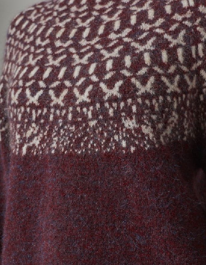 Close-up of a patterned fabric with a geometric design in red and white.