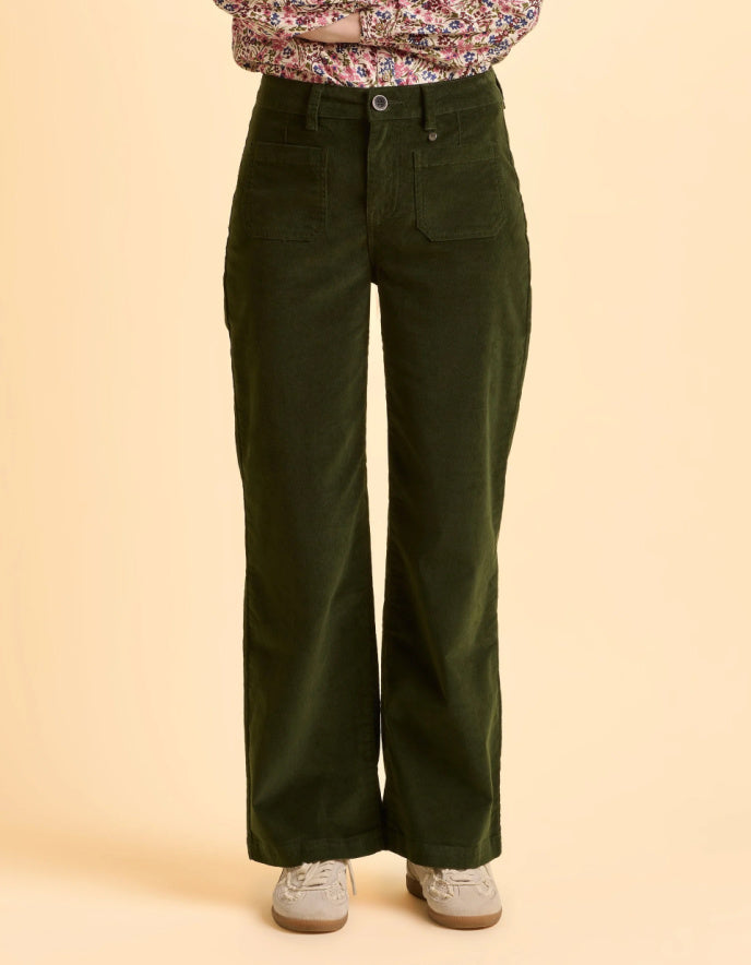 Person wearing green wide-leg pants on a beige background