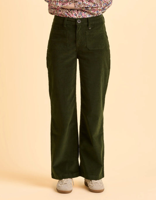 Person wearing green wide-leg pants on a beige background