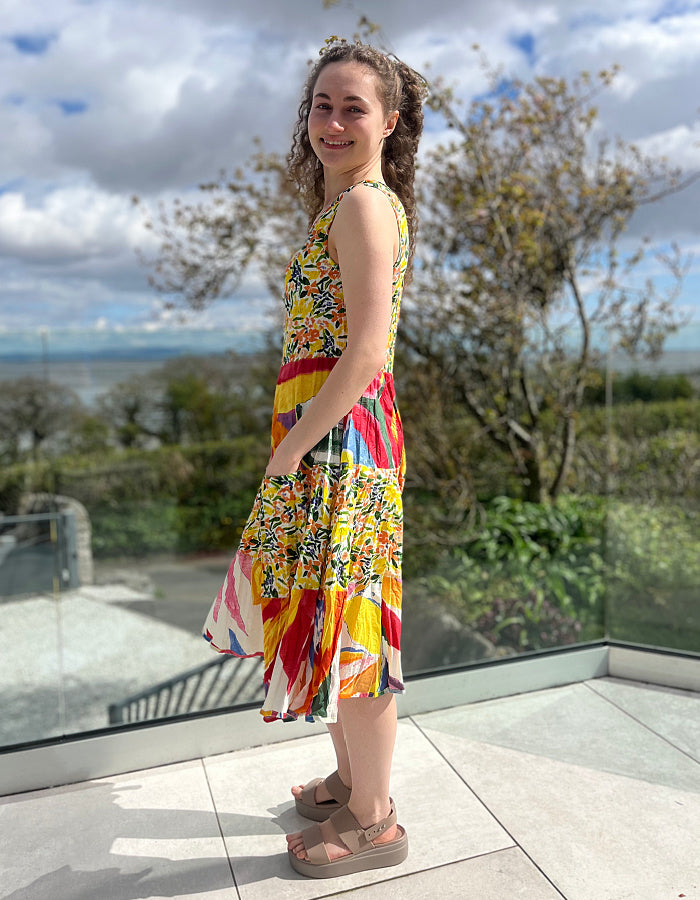 sleeveless cotton sundress with bright coloured print in collage style, tiered skirt and two front patch pockets