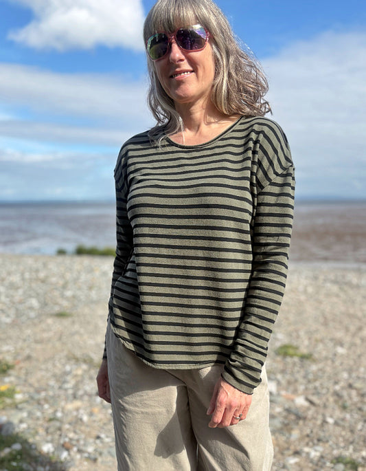 Woman wearing a striped shirt fleece t shirt and sunglasses on a beach