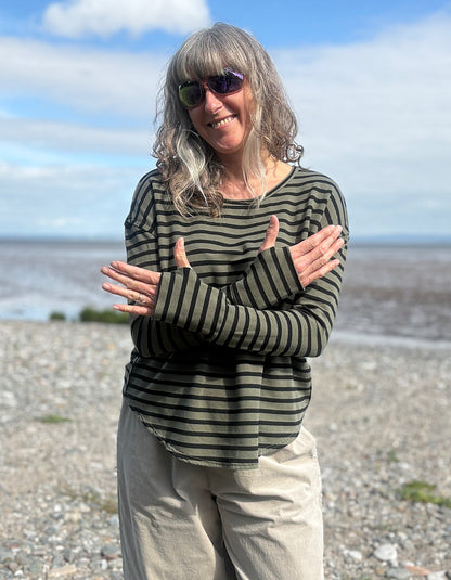 Woman wearing a striped shirt fleece t shirt with thumbholes and sunglasses on a beach