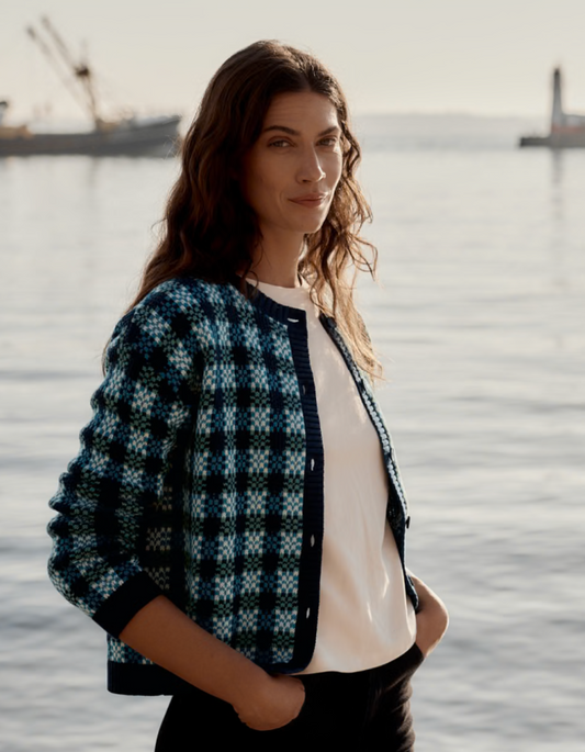 Woman wearing a patterned jacket cardigan in blues by a waterfront