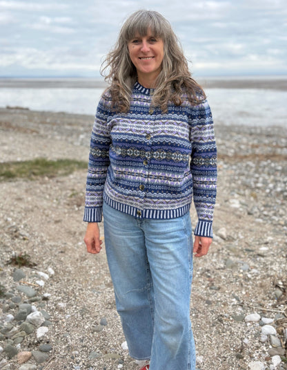 Woman wearing a blue fair isle patterned cardigan and jeans 