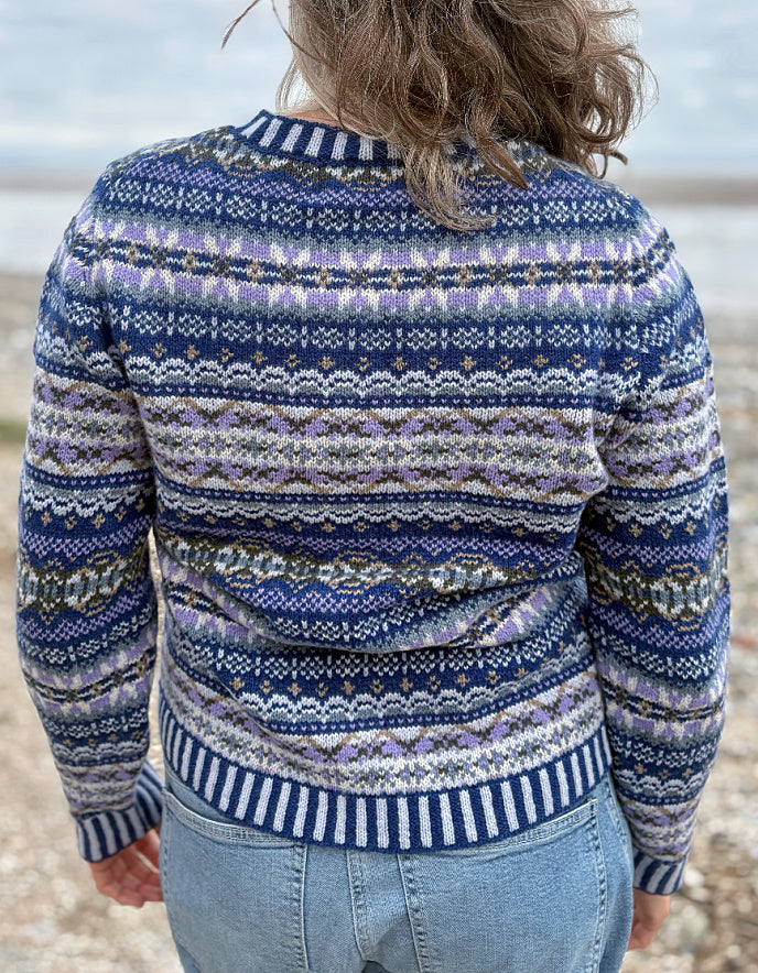 Woman wearing a blue fair isle patterned cardigan and jeans 