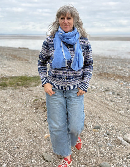 Woman wearing a blue fair isle patterned cardigan and jeans 