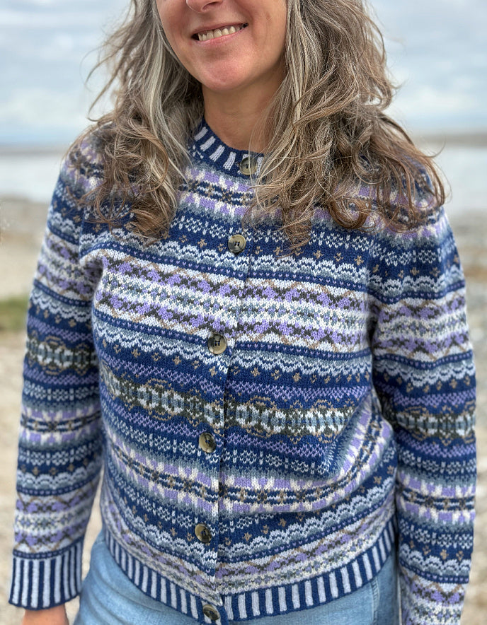 Woman wearing a blue fair isle patterned cardigan and jeans 