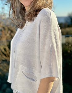 loose fit boxy white linen knitted top with elbow length sleeves and two front cut out pockets