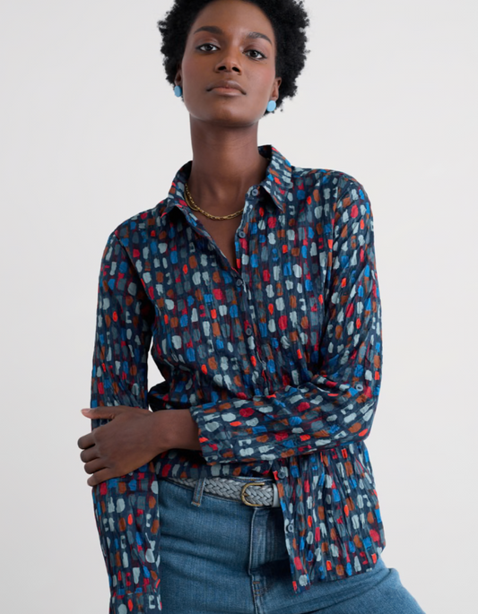 Woman wearing a patterned shirt with a plain background