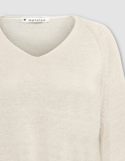 Close-up of a beige sweater on a light grey background