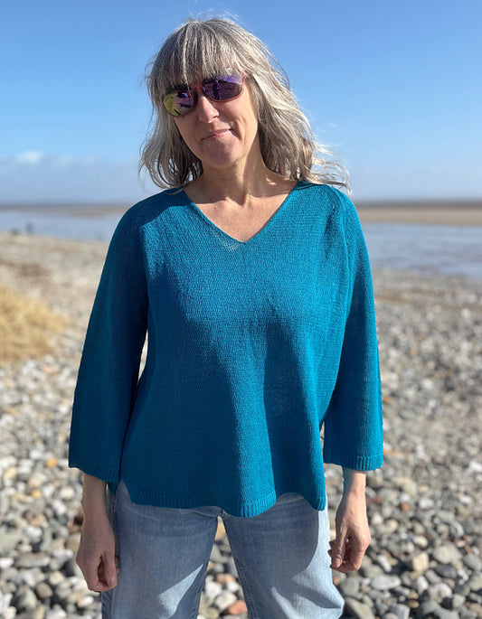 woman wearing turquoise linen knit sweater on the beach