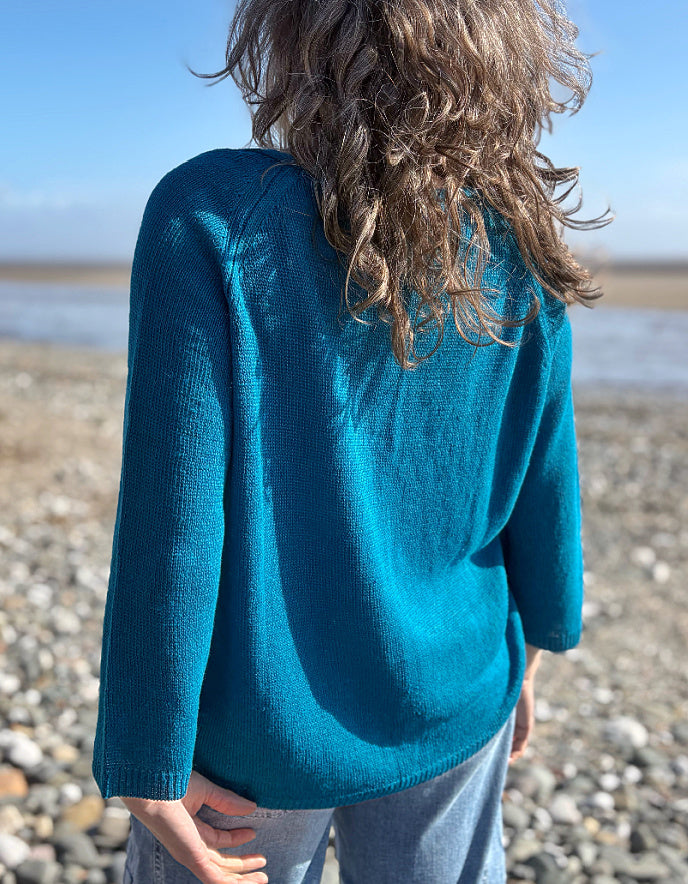 woman wearing turquoise linen knit sweater on the beach