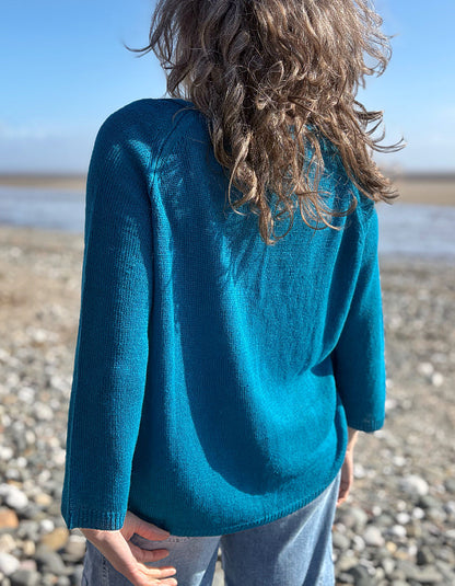 woman wearing turquoise linen knit sweater on the beach